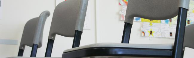 Das Bild zeigt Stühle in einem Klassenraum