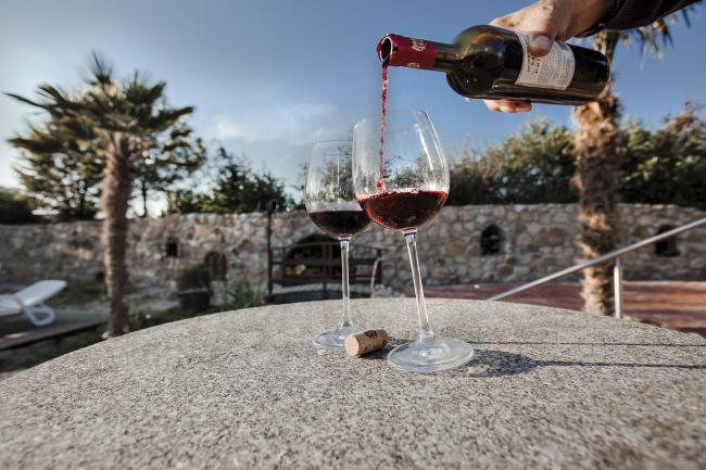 Das Bild zeigt eine Flasche Wein und ein Weinglas.