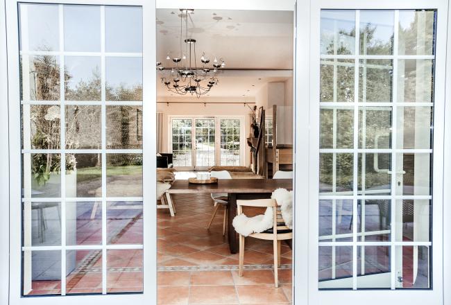 Das Bild zeigt offene Fenster und einen Hauseingang.