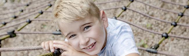 Das Bild zeigt einen Jungen auf einem Spielplatz