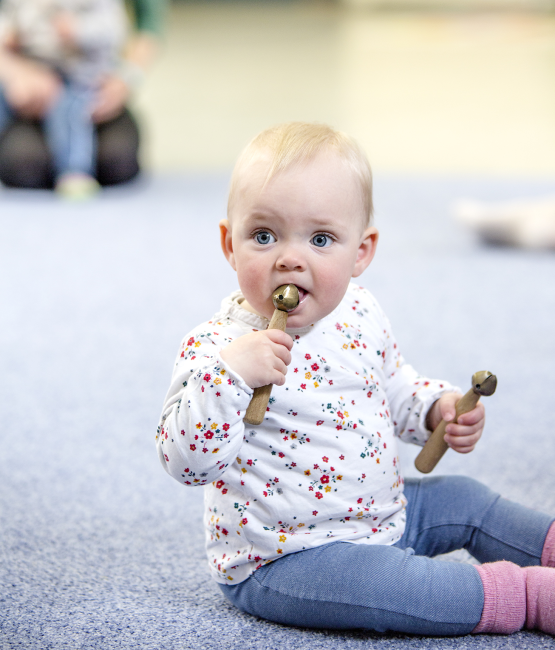 Das Bild zeigt ein Kleinkind mit einer Rassel.