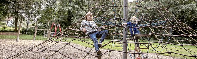 Das Bild zeigt zwei Kinder auf einem Spielplatz