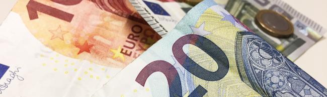 Das Bild zeigt Geldscheine und eine Münze.