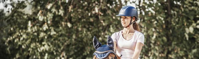 Das Bild zeigt eine Reiterin auf einem Pferd.