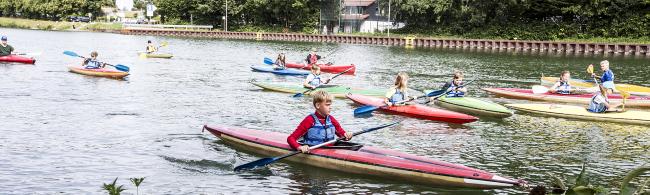 Das Bild zeigt paddelnde Jugendliche auf dem Dortmund-Ems-Kanal