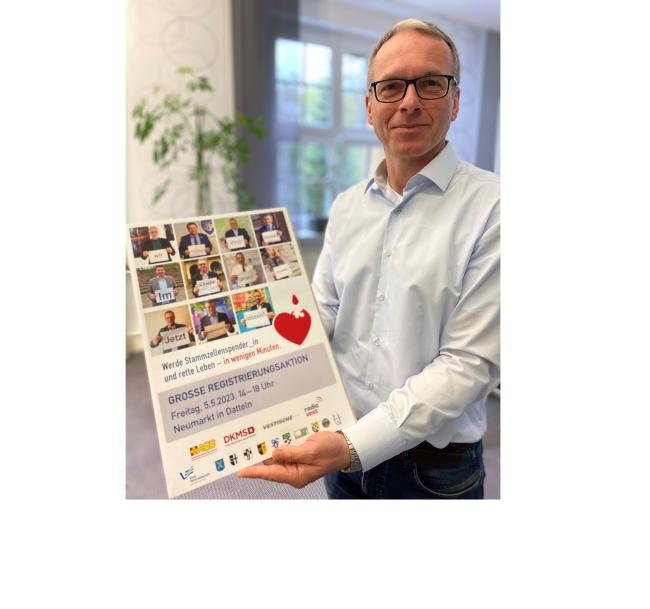 Bürgermeister André Dora zeigt das Plakat zur DKMS-Typisierungsaktion.