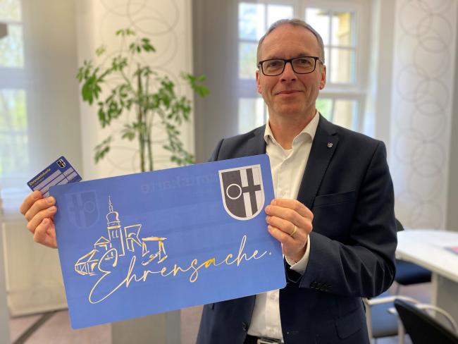 Bürgermeister André Dora zeigt die neue Dattelner Ehrenamtskarte.