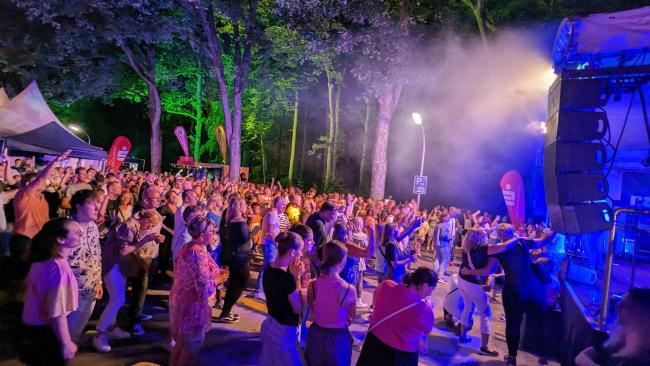 Besucherinnen und Besucher, die vor der Bühne am Rathaus stehen