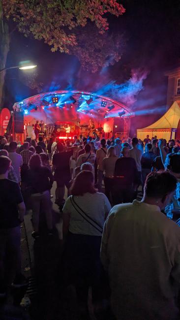 Besucherinnen und Besucher, die vor der Bühne am Rathaus stehen