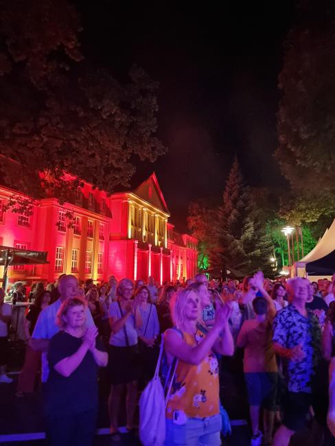 Zuschauer*innen vor dem illuminierten Rathaus