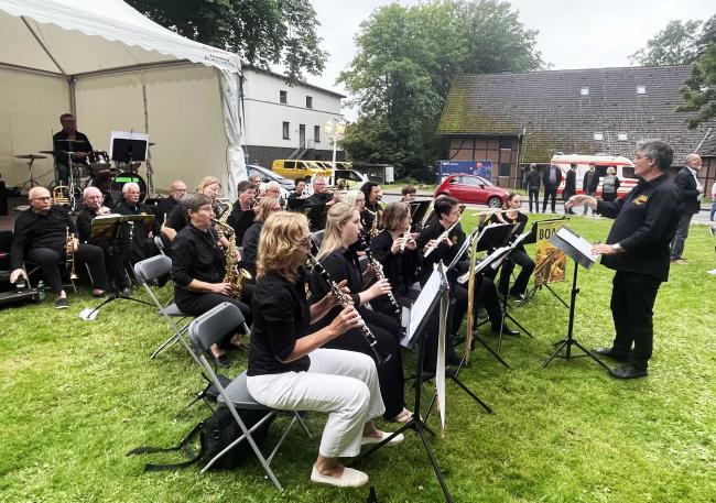 Musikerinnen und Musiker des Blasorchesters BOA der Musikschule auf der Wiese zwischen Rathaus und Dorfschultenhof