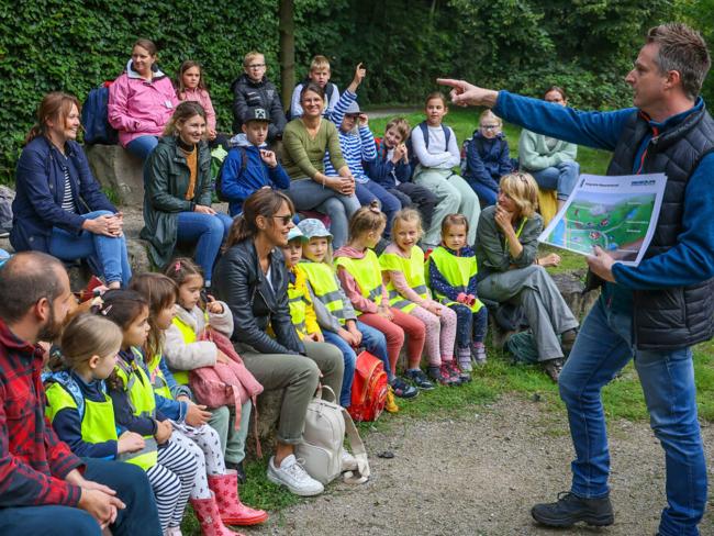 Ein Erwachsener auf der rechten Seite erklärt Kindern anhand eines Schaubilds das Blaue Klassenzimmer.