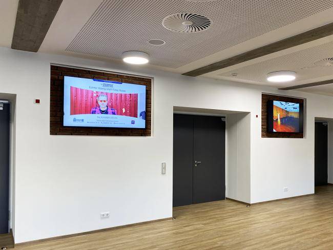 Zwei Bildschirme im Foyer der Stadthalle
