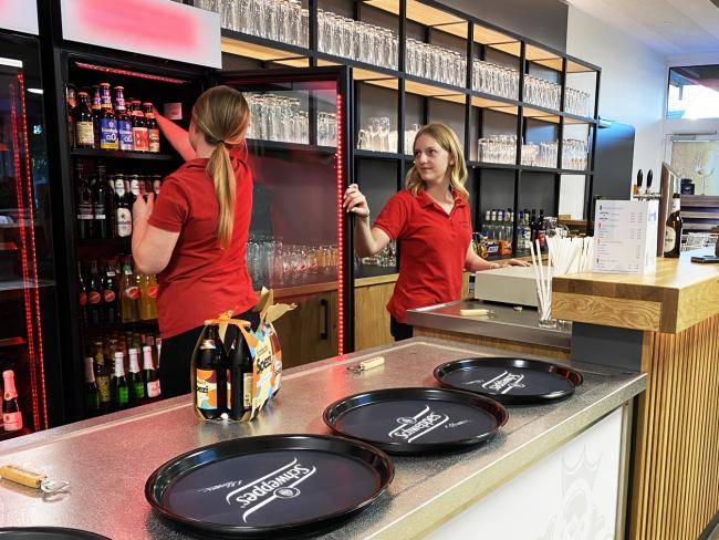 Zwei Servicekräfte hinter der Theke im Foyer