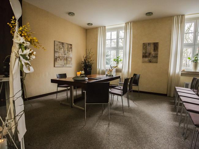 Trauzimmer im Rathaus, links eine Kerze in einem Glasbehälter, in der Mitte ein Tisch mit verschiedenen Gegenständen, rechts die Stuhlreihen, auf denen die Gäste bei den Trauungen sitzen