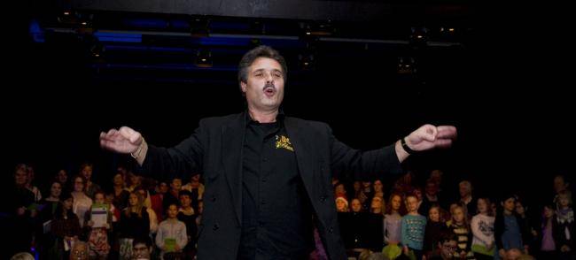 Michael Althoff mit ausgebreiteten Händen vor dem Blasorchester BOA beim Weihnachtskonzert 2015