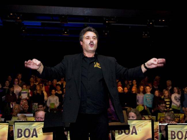 Michael Althoff mit ausgebreiteten Händen vor dem Blasorchester BOA beim Weihnachtskonzert 2015