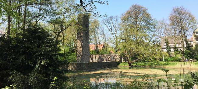 Ehrenmal an der Castroper Straße, im Vordergrund ein Teich, ringsherum Bäume und Sträucher.