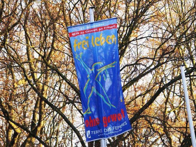 Fahne vor Bäumen mit der Aufschrift: Nein zu Gewalt an Frauen, 25. November, frei leben, ohne Gewalt, Terre de Femmes, www.frauenrechte.de 