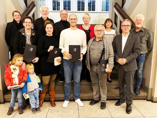 Das Foto zeigt von links auf der Treppe im Rathaus folgende Erwachsene: Umweltbeauftragte Jasmin König, Lars Pompös, Theodor Beckmann (WV Die Grünen), Melanie Bleicher, Falco Böhlje, Keven Hebekeuser, Petra Willemsen (DIE LINKE), Günter Jordan, Gabriele Weigand (UBP), Bürgermeister André Dora und Joachim Lehmann (SPD).