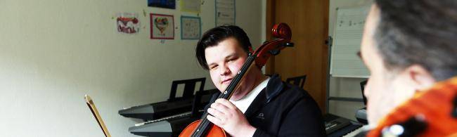 Ein Musikschullehrer erklärt das Cellospielen