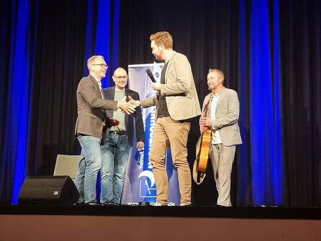 von links: Bürgermeister André Dora, Sparkassen-Marktbereichsleiter Stefan Merten, Lehrerkind Bastian Bielendorfer und Helmut Sanftenschneider bei der Verleihung des Ehrenpreises in der Stadthalle