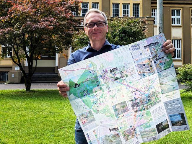 Andre Dora präsentiert den touristischen Stadtplan vor dem Dattelner Rathaus