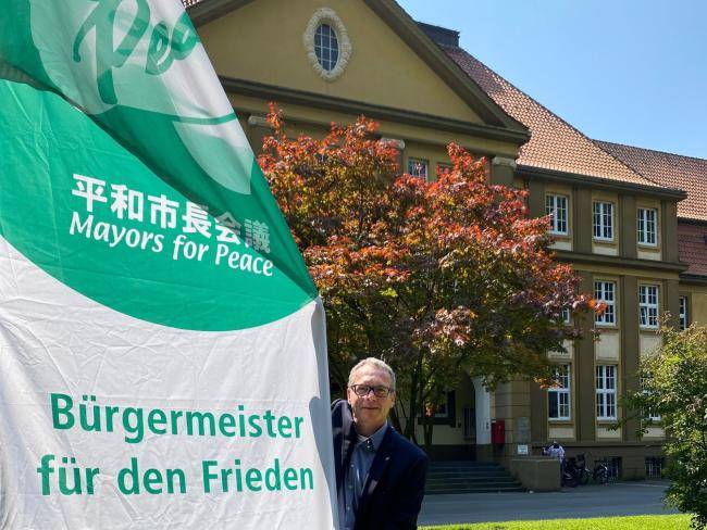 Bürgermeister André Dora mit Mayors-for-Peace-Flagge 2024