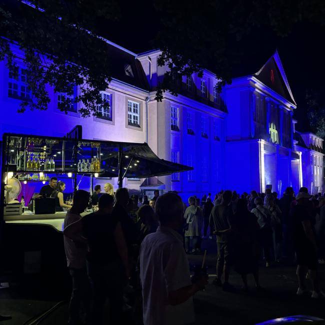 Cocktailbar vorm beleuchteten Rathaus