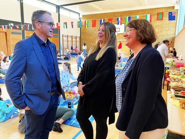 Bürgermeister André Dora, Kim Starschinski (Leiterin der Kita ARTIKUS) und Xenja Winziger (Koordination Kinderbetreuung) im Gespräch beim Interkulturellen Picknick der Kita ARTIKUS