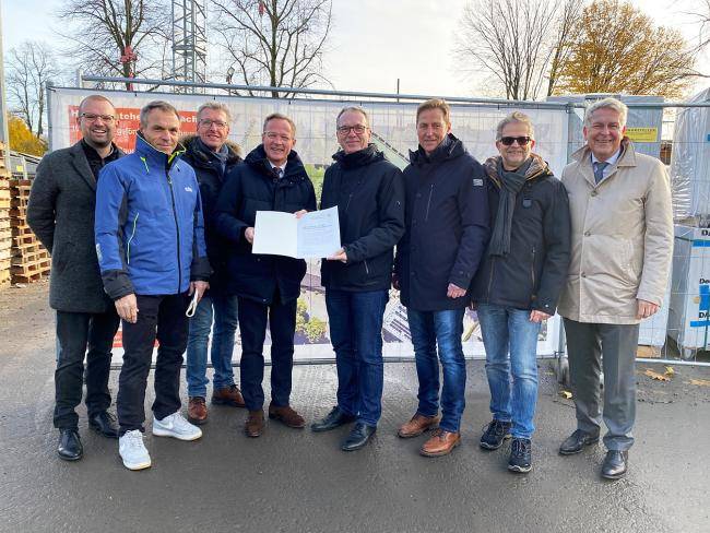 Übergabe Förderbescheid für geförderte Wohnungen Am Alten Schulgarten in Horneburg. Das Bild zeigt von links:  Foto von links: Dominik Schad (Kreisdirektor), Dirk Neugebauer (Architekt), Ralf Schnettger (kaufmännischer Geschäftsführer SEG), Staatssekretär Daniel Sieveke (Ministerium für Heimat, Kommunales, Bau und Digitalisierung des Landes NRW), Bürgermeister André Dora, Frank Kuhs (technischer Geschäftsführer SEG), Rüdiger Korte (Sparkasse Vest Recklinghausen) und Dr. Peter Lucke (stellvertr. Vorstand)