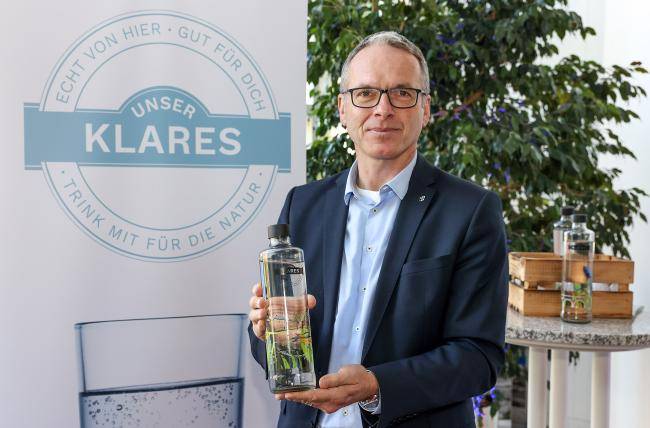 Bürgermeister André Dora präsentiert Unser Klares Trinkwasserflasche