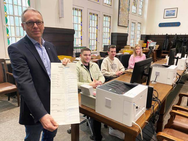 Bürgermeister André Bürgermeister mit einem Stimmzettel für die Bundestagswahl – daneben vom Wahlamt Alexander Pepping, Veith Gale und Svenja Milevskij.