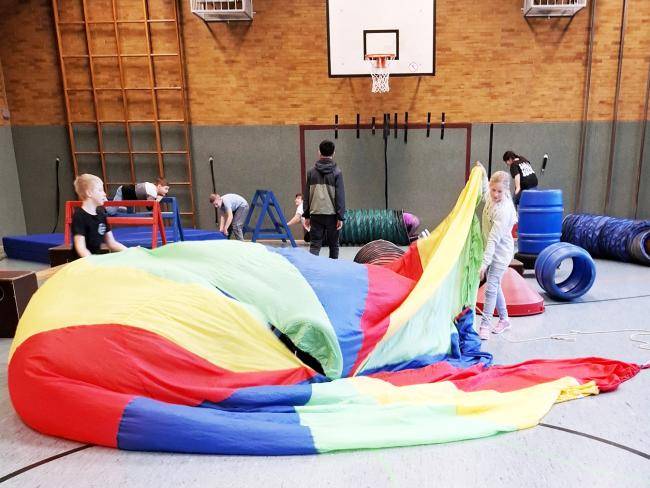 Kinder mit der Elementen der Mobilen Bewegungsbaustelle in der Sporthalle der Böckenheckschule 