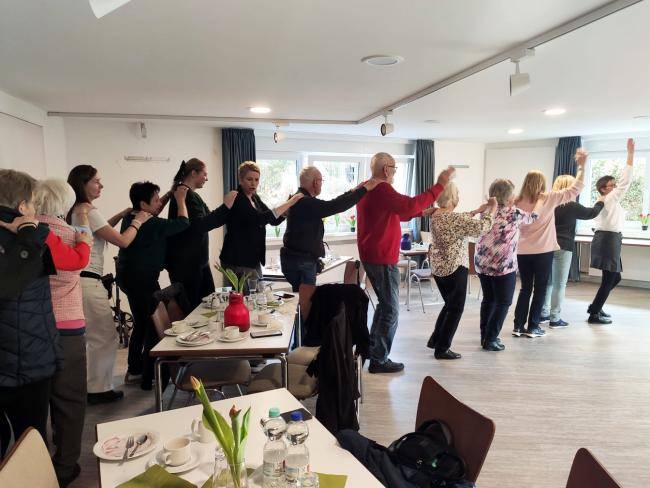 Teilnehmer*innen des Tanztees tanzen eine Polonaise