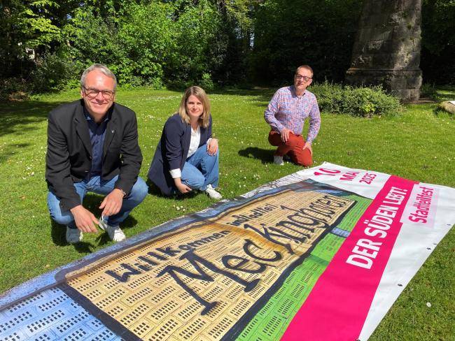 Bürgermeister André Dora (l.) stellte das Banner zum Stadtteilfest heute zusammen mit Sabrina Müthing (Organisatorin des Stadtteilfestes) und Dezernent Peter Wenzel vor.