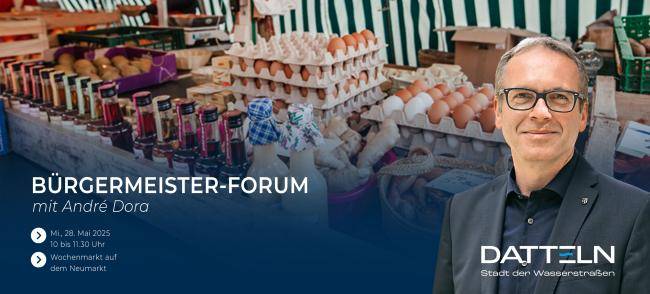 Bürgermeister André Dora vor einem Bild, das einen Stand auf dem Wochenmarkt zeigt.