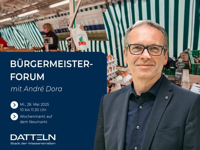 Bürgermeister André Dora vor einem Bild, das einen Stand auf dem Wochenmarkt zeigt.