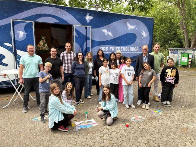 Bürgermeister André Dora mit Kindern der OGS Böckenheckschule und deren Leiterin Elisabeth Preuß und Mitarbeiter*innen der Stadtverwaltung.