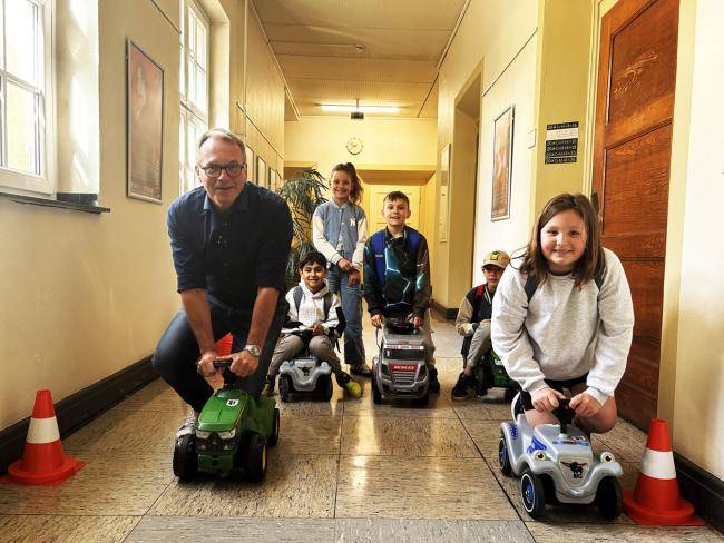 Bürgermeister André Dora beim Bobbycarrennen mit Schüler*innen im Rathaus