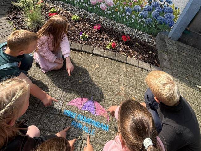 Mit einer Schablone haben die Kinder der Kita Hachhausen das Motto "Viele gemeinsam für alle" auf den Boden gesprüht.