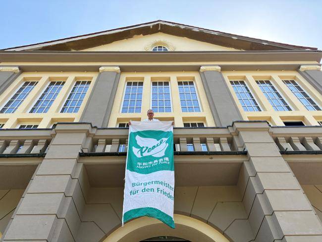 Bürgermeister André Dora mit Mayors-for-Peace-Flagge