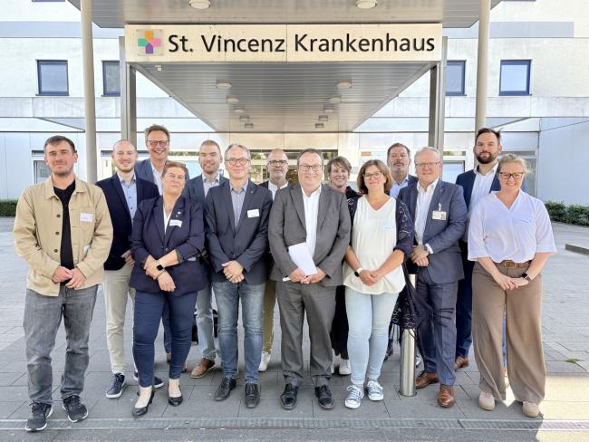 NRW-Minister Oliver Krischer unter anderem mit Bürgermeister André Dora vor dem St.-Vincenz-Krankenhaus