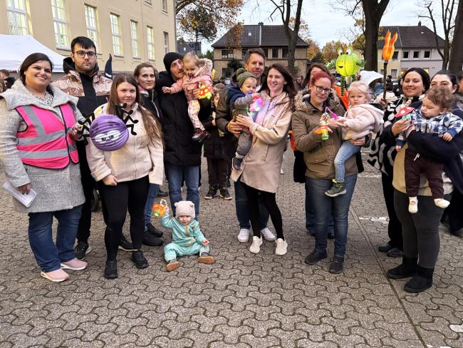 Eltern mit Kindern der Kindertagespflege beim Lichterfest hinter dem Rathaus, links eine Mitarbeiterin des Jugendamts