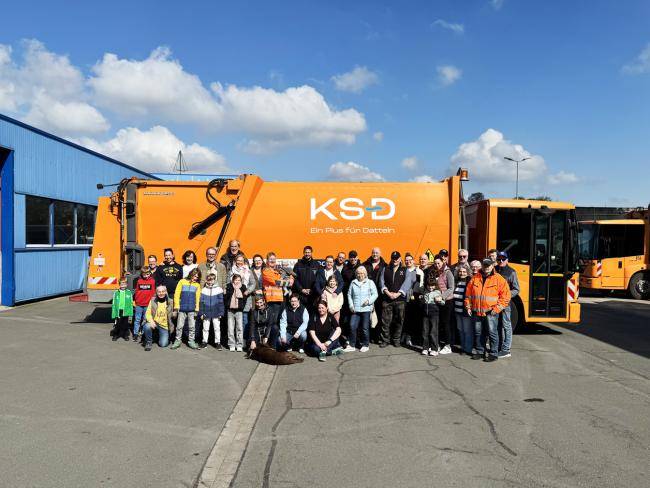 Teilnehmer*innen des Flurreinigungstages, Bürgermeiser und KSD-Mitarbeiter*innen vor einem Abfallsammelfahrzeug auf dem Betriebshof.
