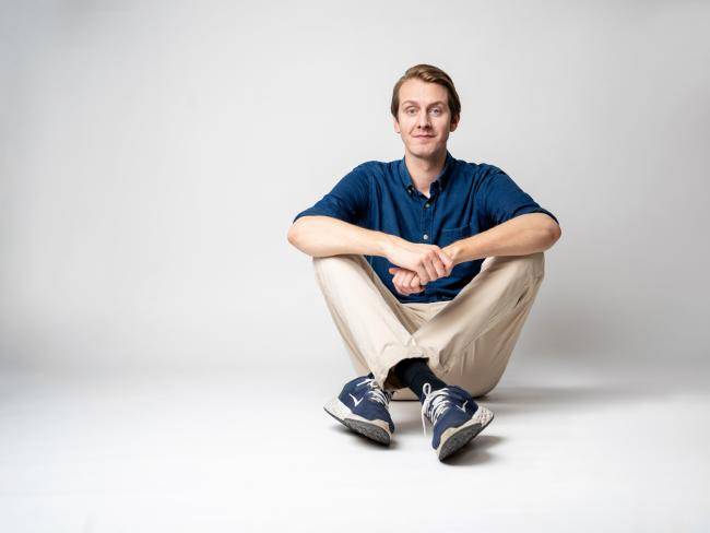 Das Bild zeigt Jonas Greiner, der auf dem Boden sitzt