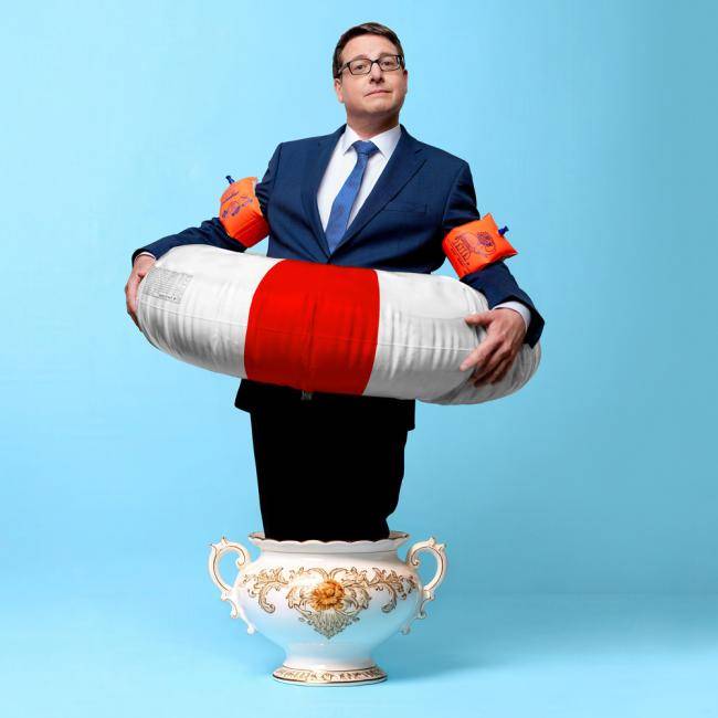 Kai Magnus Sting steht mit Rettungsring und Schwimmringen in einem großen Suppentopf