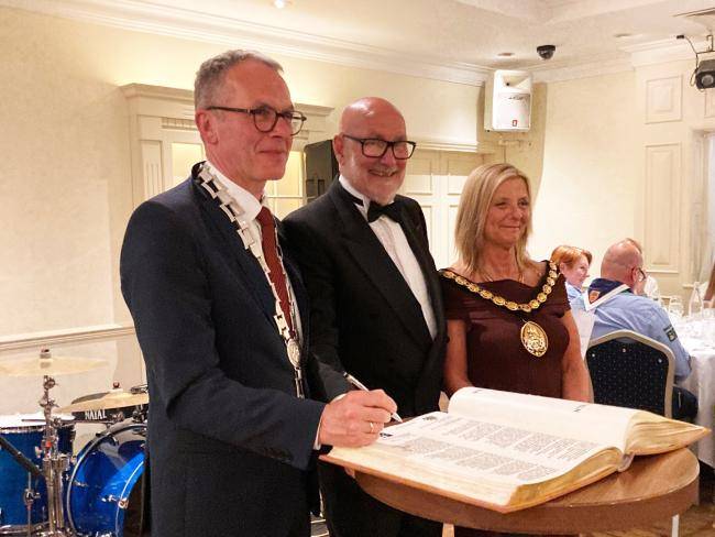 Bürgermeister André Dora, Julie Aston (Vorsitzende des Rates von Cannock Chase) und Ratsführer Steve Thornley tragen sich in das Goldene Buch ein.