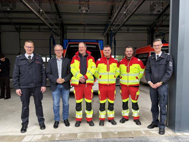 Bürgermeister André Dora mit dem Leiter der Feuerwehr und seinem Stellvertreter sowie drei Personen vom Rettungsdienst in der neuen Rettungswache.
