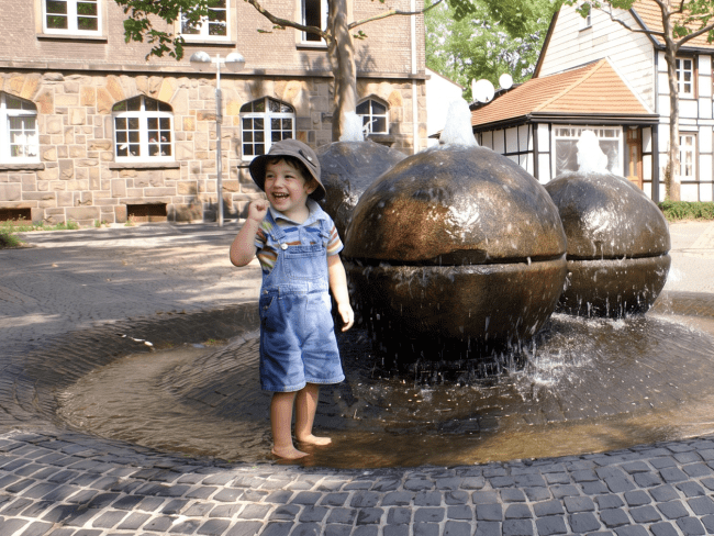 Kind am Tigg-Brunnen - Hinweis: Das Gesicht wurde mit KI geändert